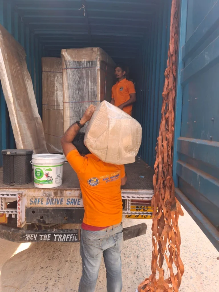 Worker lifting packed items for loading by Mehar Packers and Movers in Patna.